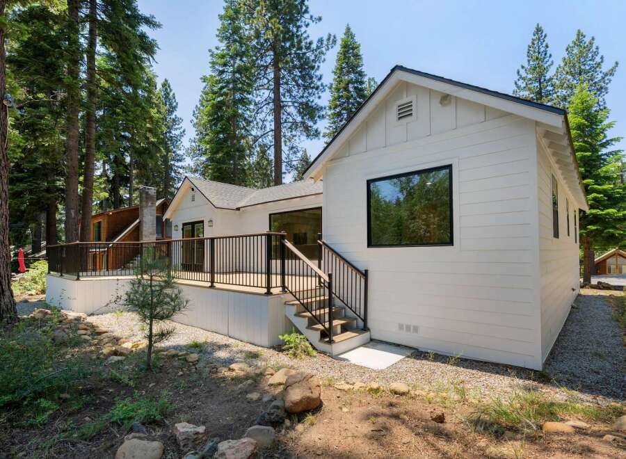 Experience modern living nestled amongst tall pine trees in this stunning white home.