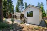 Experience modern living nestled amongst tall pine trees in this stunning white home.