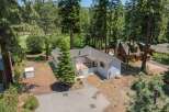 Nestled amidst tall pine trees, this charming white home offers a serene retreat.