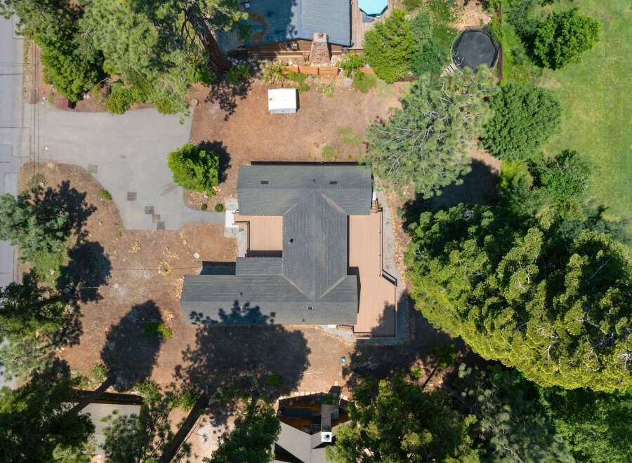 Discover this stunning property from an aerial perspective, showcasing a spacious home with an expansive deck perfect for outdoor entertaining.