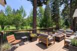 Experience outdoor living at its finest on this expansive deck, perfect for entertaining or relaxing amidst a serene, wooded setting with golf course views.