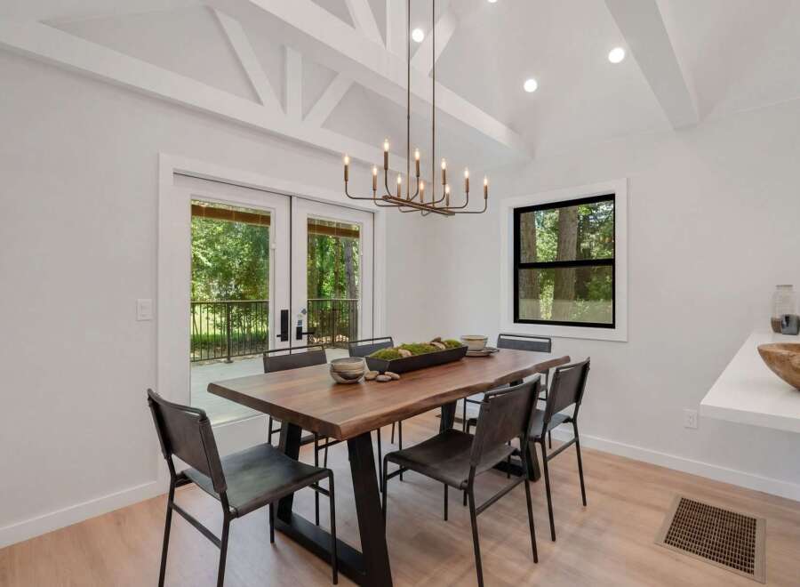 Experience modern dining in this beautifully appointed space, featuring a live-edge wood table and sleek metal chairs.