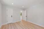 Step into this bright and airy room featuring a modern aesthetic with clean white walls and sleek doors.