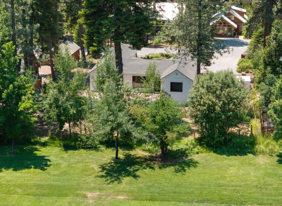Nestled amidst lush greenery and mature trees, this property offers a serene retreat with multiple charming structures.