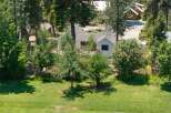 Nestled amidst lush greenery and mature trees, this property offers a serene retreat with multiple charming structures.