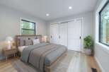 Experience serene living in this beautifully appointed bedroom, featuring a plush upholstered headboard and comfortable bedding.