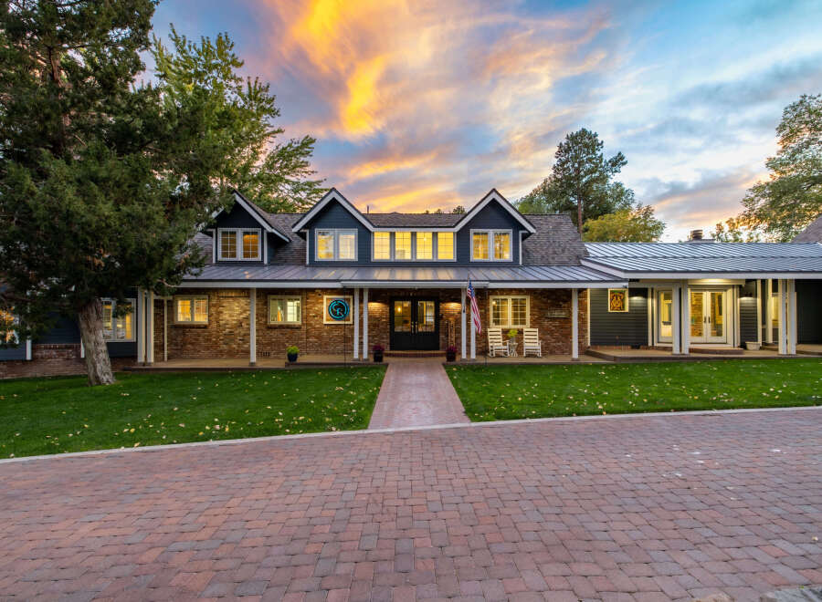 Experience luxury living in this stunning home featuring a beautiful brick facade and a welcoming covered porch.