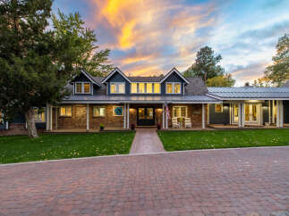 Experience luxury living in this stunning home featuring a beautiful brick facade and a welcoming covered porch.