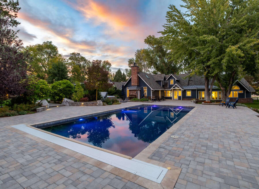 Experience luxury living with this stunning property featuring a beautifully illuminated swimming pool and expansive paver patio, perfect for outdoor entertaining.