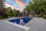 Experience luxury living with this stunning property featuring a beautifully illuminated swimming pool and expansive paver patio, perfect for outdoor entertaining.