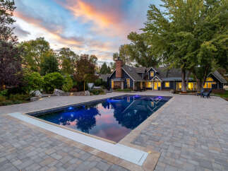 Experience luxury living with this stunning property featuring a beautifully illuminated swimming pool and expansive paver patio, perfect for outdoor entertaining.