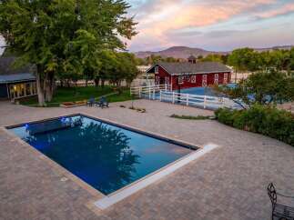 Experience luxury outdoor living with this stunning property featuring a rectangular swimming pool and a full-size basketball court.