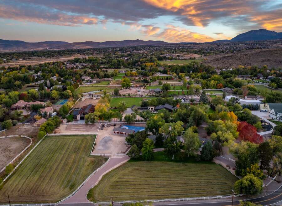 Experience luxury living in this sprawling estate, featuring meticulously maintained grounds with lush green fields and vibrant autumn foliage.
