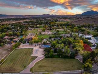 Experience luxury living in this sprawling estate, featuring meticulously maintained grounds with lush green fields and vibrant autumn foliage.