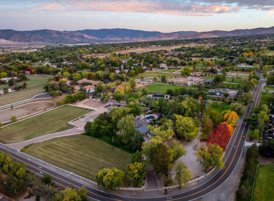 Discover this stunning property featuring expansive grounds perfect for equestrian activities, complete with white-fenced pastures and riding areas.