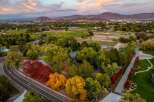 Experience the beauty of autumn with this stunning aerial view of a property surrounded by vibrant fall foliage.