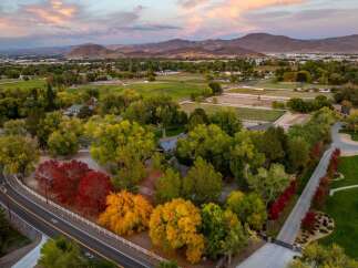 Experience the beauty of autumn with this stunning aerial view of a property surrounded by vibrant fall foliage.