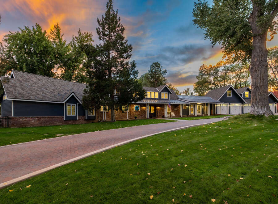 Experience luxury living in this stunning home featuring a long, winding brick driveway leading to a beautifully appointed facade.