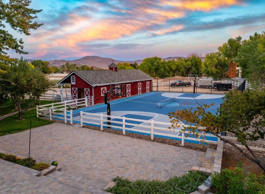 Experience the ultimate outdoor lifestyle with this stunning property featuring a regulation-size basketball court and a charming red barn.
