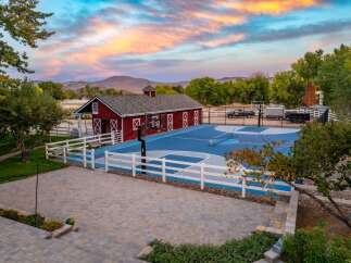 Experience the ultimate outdoor lifestyle with this stunning property featuring a regulation-size basketball court and a charming red barn.