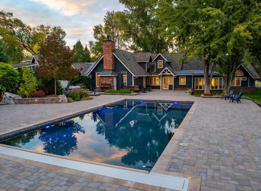Experience luxury outdoor living with this stunning property featuring a sparkling swimming pool and expansive paver patio, perfect for entertaining.