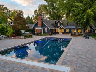 Experience luxury outdoor living with this stunning property featuring a sparkling swimming pool and expansive paver patio, perfect for entertaining.