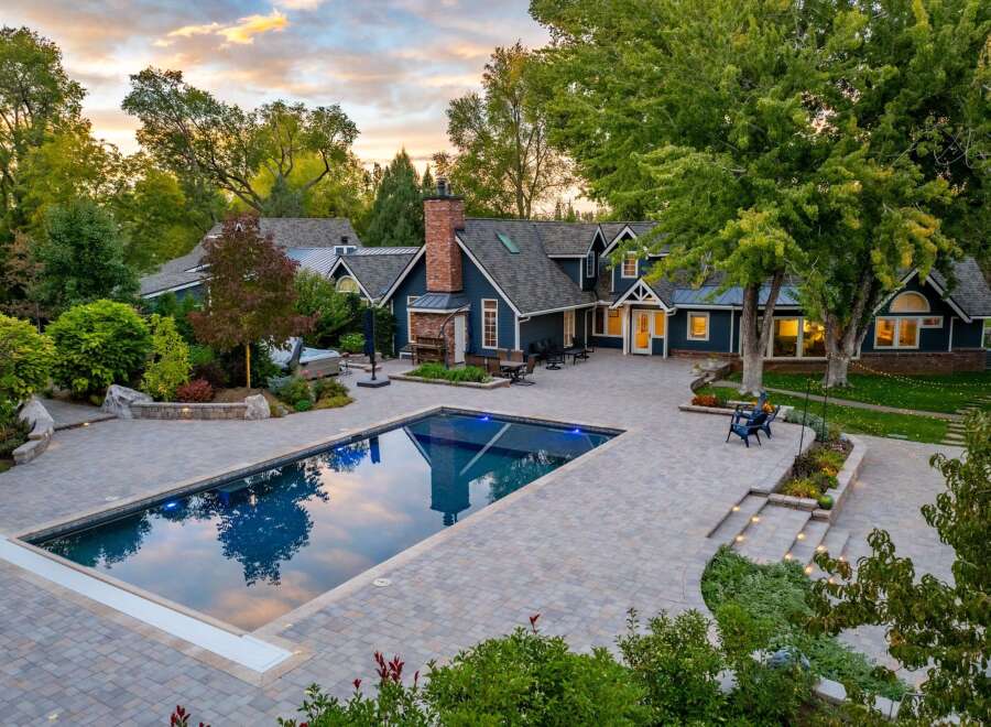 Experience luxury outdoor living with this stunning property featuring a pristine rectangular swimming pool and an adjacent hot tub, perfect for relaxation and entertainment.