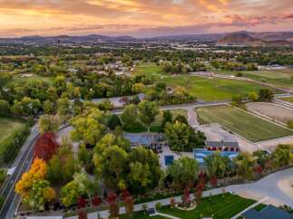Experience luxury living in this expansive estate featuring a stunning residence, a vibrant blue swimming pool, and a full-size basketball court.