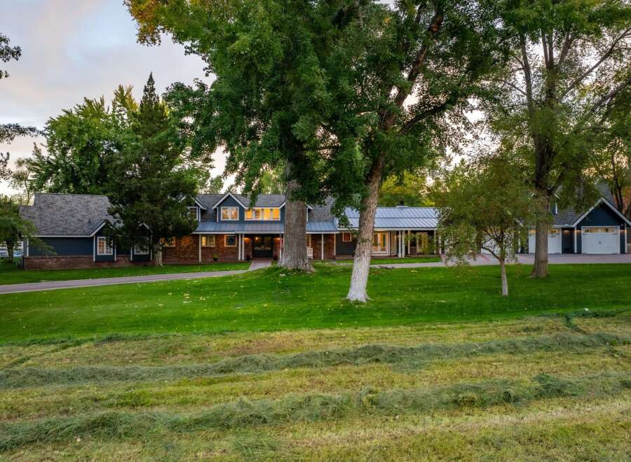 Discover this stunning property featuring a spacious, multi-level home with a classic brick and dark blue siding exterior.