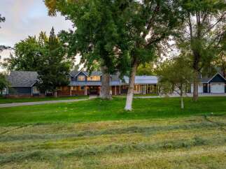 Discover this stunning property featuring a spacious, multi-level home with a classic brick and dark blue siding exterior.