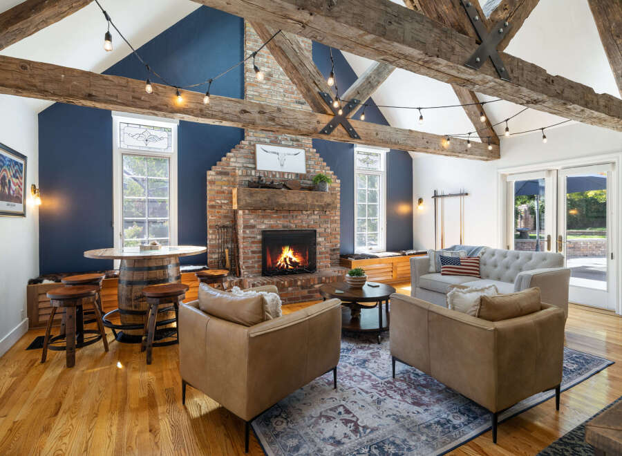 Experience rustic charm in this inviting living room, featuring exposed wooden beams and a striking brick fireplace.