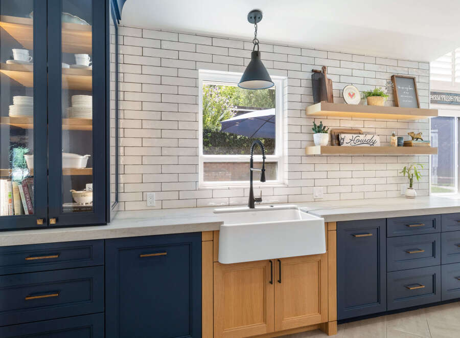 Discover a stunning kitchen featuring deep navy cabinetry paired with warm wood accents, creating a sophisticated and inviting atmosphere.