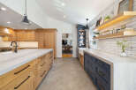 Experience the perfect blend of modern and rustic in this stunning kitchen, featuring custom wood cabinetry and sleek navy blue lower cabinets.