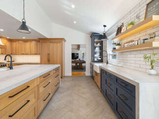 Experience the perfect blend of modern and rustic in this stunning kitchen, featuring custom wood cabinetry and sleek navy blue lower cabinets.