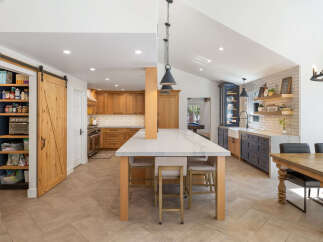 Discover this stunning kitchen featuring a spacious island with a marble countertop, perfect for meal prep and casual dining.