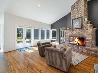 Experience cozy evenings by the stunning brick fireplace in this inviting living room.