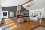 Experience the warmth of this inviting living room, featuring a stunning floor-to-ceiling brick fireplace as the centerpiece.