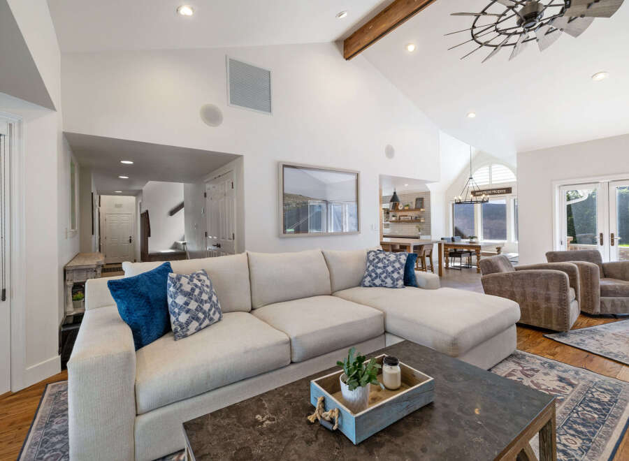 Experience luxurious living in this spacious great room, featuring a large sectional sofa and comfortable armchairs perfect for relaxation.
