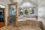 Indulge in luxury in this stunning master bathroom featuring a spacious walk-in shower with elegant tilework and a deep soaking tub.