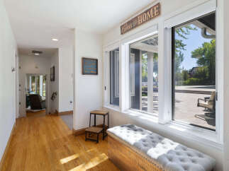 Step into this charming entryway featuring warm hardwood floors and a welcoming ambiance.