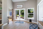 Step into this inviting entryway featuring a motivational 'Never Give Up' sign above elegant double doors that open to a lush backyard.