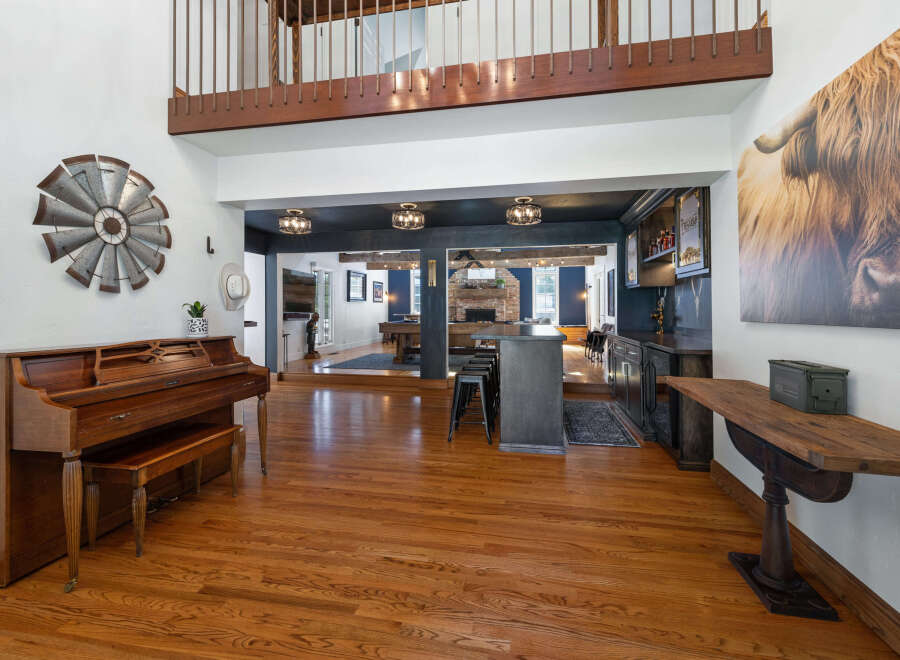 Step into this spacious and inviting home, featuring a grand entryway with a beautiful wooden piano and a striking windmill wall art.