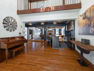 Step into this spacious and inviting home, featuring a grand entryway with a beautiful wooden piano and a striking windmill wall art.