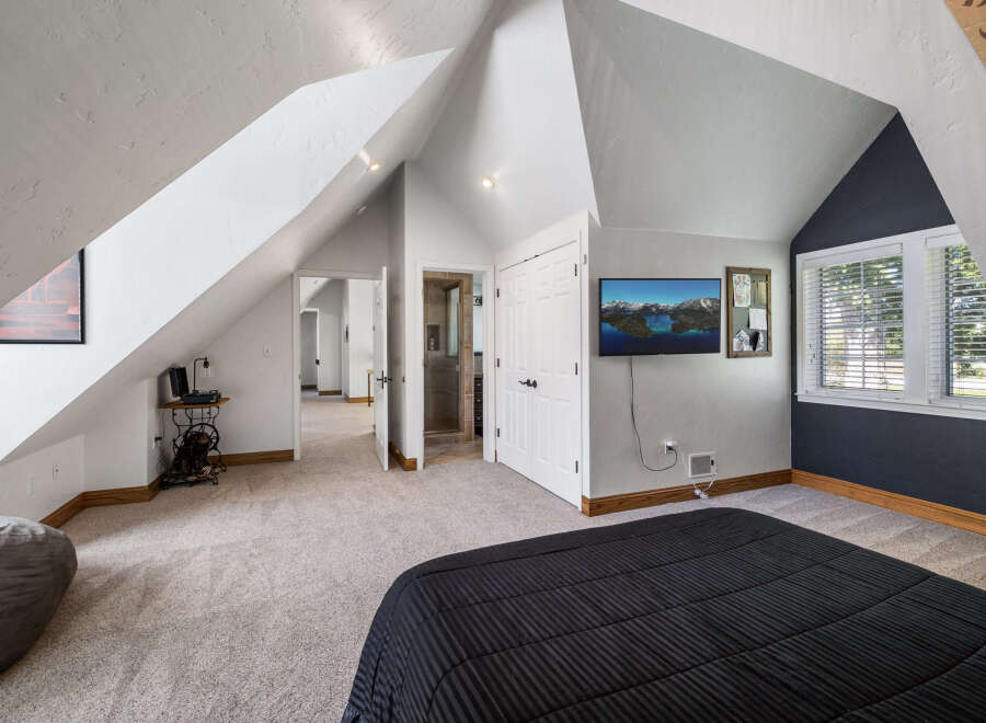 Discover this charming attic bedroom featuring a spacious layout and unique architectural angles.