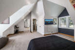 Discover this charming attic bedroom featuring a spacious layout and unique architectural angles.