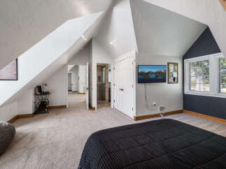 Discover this charming attic bedroom featuring a spacious layout and unique architectural angles.