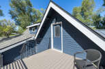 Enjoy outdoor living on this charming deck, complete with a modern wicker chair perfect for relaxing.