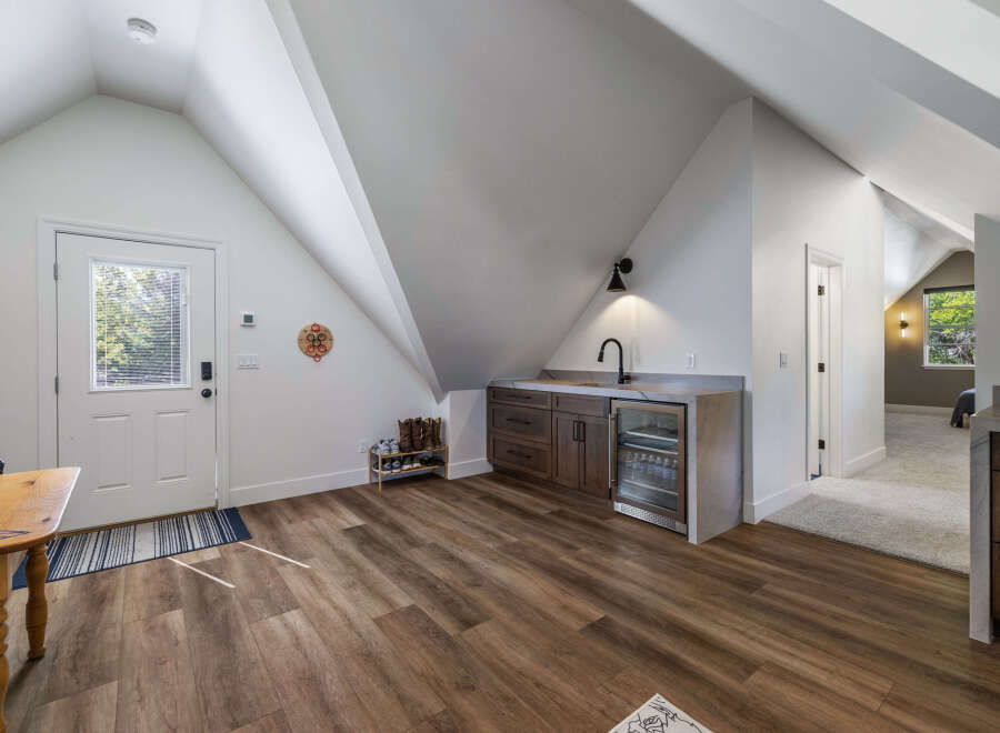 Discover this charming space featuring a convenient wet bar with a mini-fridge and ample cabinet storage, perfect for entertaining.