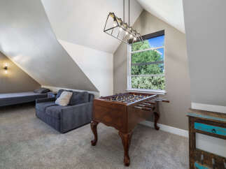 This spacious attic room offers a versatile living space with a comfortable sofa and a twin bed, perfect for guests or a cozy retreat.