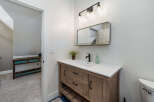 This bathroom features a stylish wooden vanity with a white countertop and a modern black faucet.